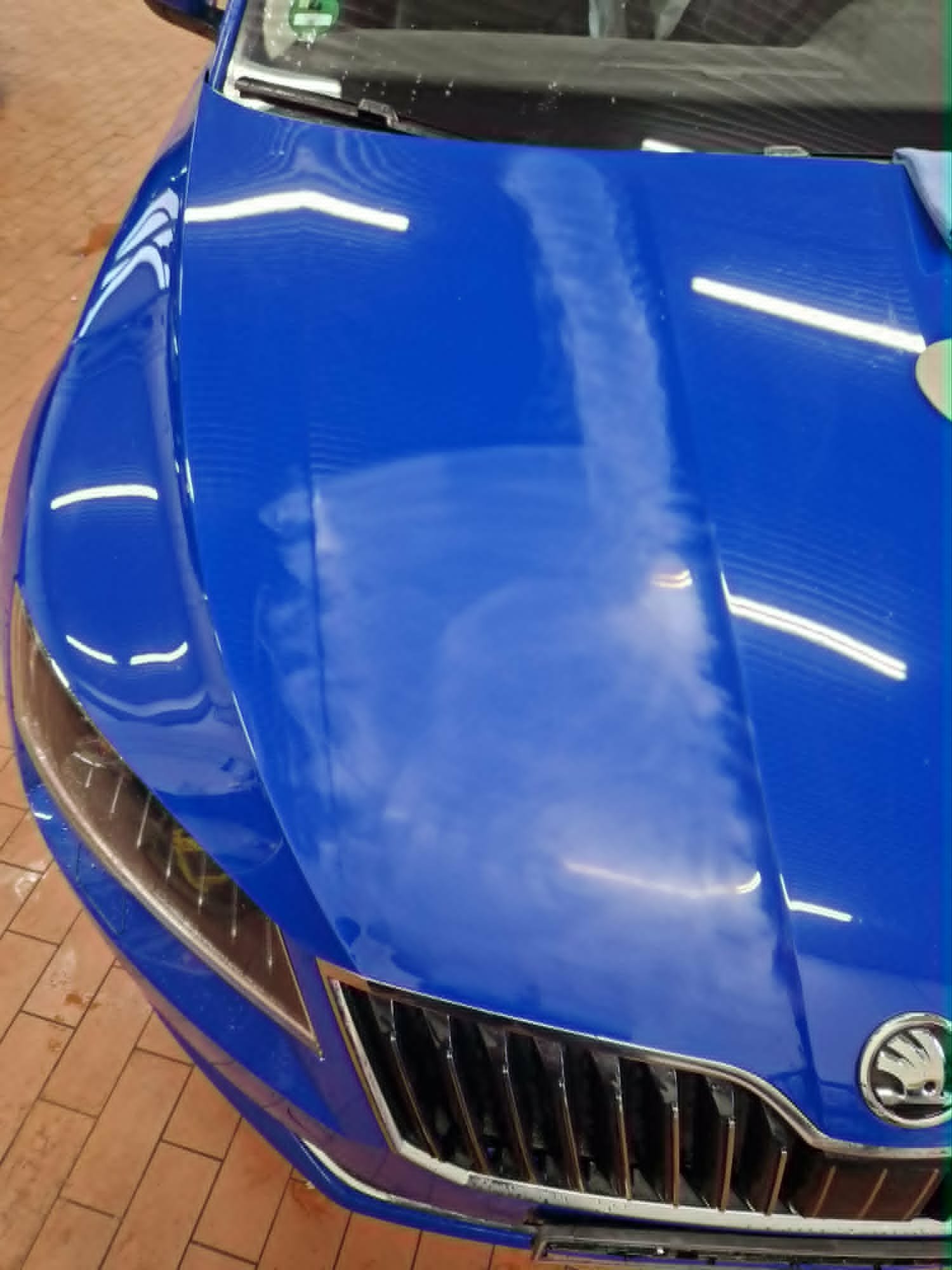 Frisch aufbereitete blaue Fahrzeugfront mit spiegelnder Lackoberfläche