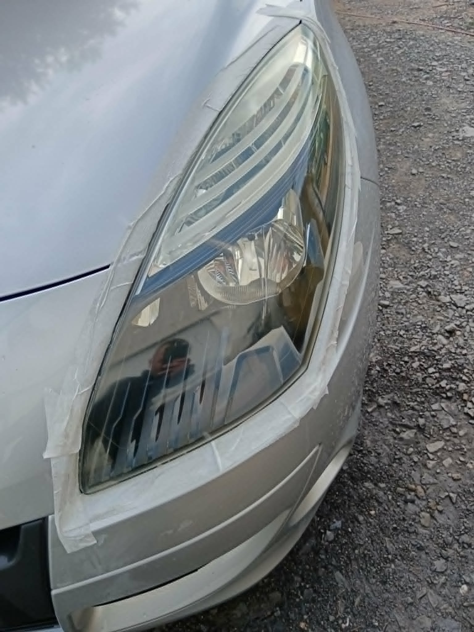 Abgeklebter Fahrzeugscheinwerfer während der Aufbereitung